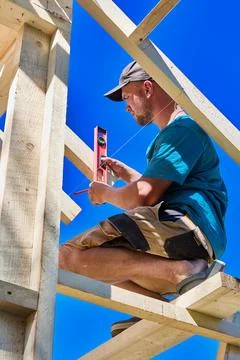 Wooden makeshift scaffolding supports young construction worker checking ti.. Stock Photos