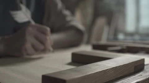 Wooden measuring square tool on a table against a blurred master writing Stockbeeldmateriaal 339631235