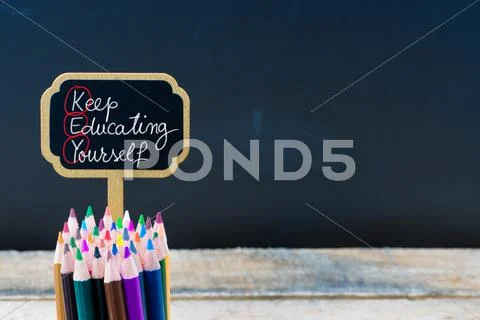 Wooden mini blackboard label with message Key Keep Educating Yourself Stock Photos