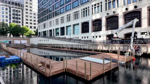Wooden modular floating platforms under construction on Canary Wharf dock Stock Footage 336616190