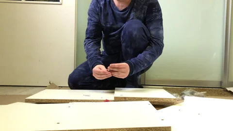 Wooden modular rack. Assembling a modular rack. A man installs an eccentric.. Video stock 228317780