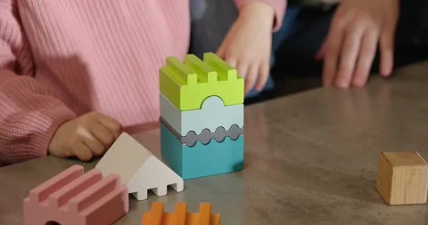 Wooden multi-colored bricks on the table. The child collects colorful wooden cub Video stock 277480891