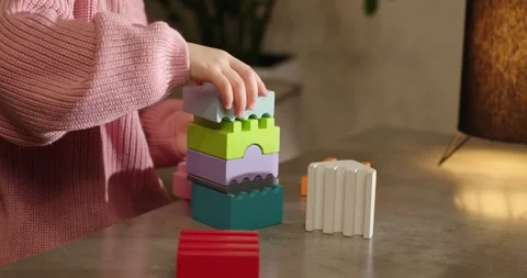 Wooden multi-colored bricks on the table. The child collects colorful wooden cub Video stock 277481013