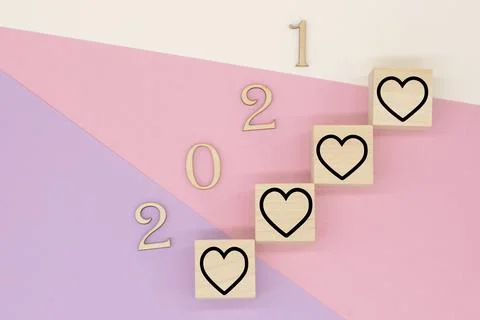 Wooden numbers 2021 and hearts on a pastel background Stock Photos