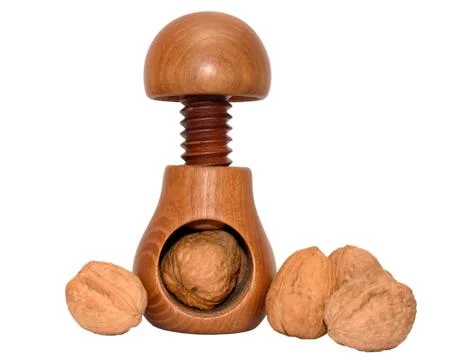 A wooden nutcracker and walnuts. Stock Photos