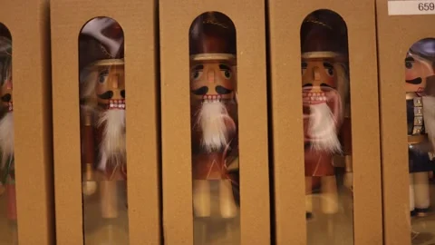 Wooden nutcracker figures with white beards displayed in brown cardboard boxes s Stock Footage 318869451