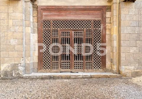 Wooden ornate door over stone brick wall Stock Photos
