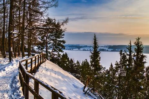 The Wooden Path Under the Snow with a View of Frozen Lake Stock Photos