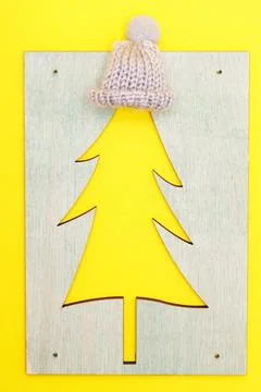 Wooden pattern of a Christmas tree with a hat on a yellow background. 스톡 사진