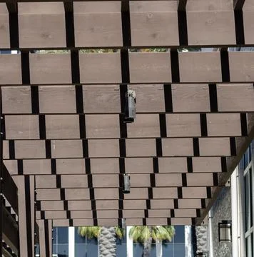 Wooden pergola ceiling with grid pattern and spotlights creating structured Stock Photos