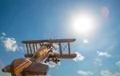 The wooden plane fly on the background of a bright sun Photo