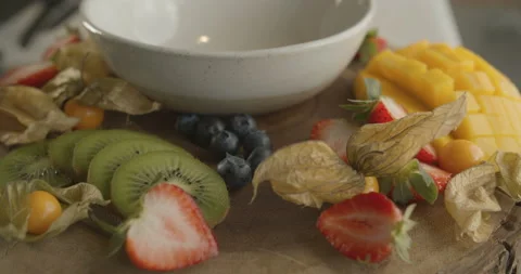 Wooden plate with fruit platter, mango, kiwi, strawberries and blueberries Stock Footage 103797766