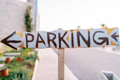 Wooden pointer with an arrow. Caption: Parking Wooden pointer with an arro... Stock Photos