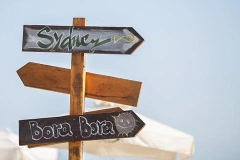 Wooden pointer post with copy space at the beach. arrows on a guidepost point Stock Photos