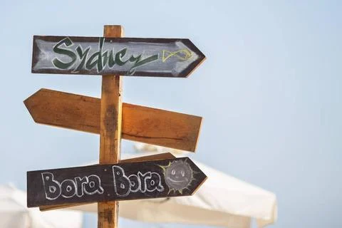 Wooden pointer post with copy space at the beach. arrows on a guidepost po... Foto stock