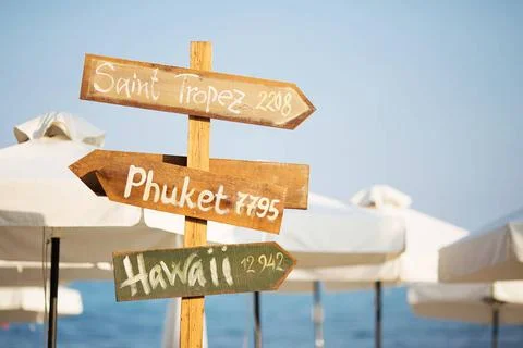 Wooden pointer post with copy space at the beach. arrows on a guidepost po... Foto stock