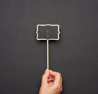 Wooden pointer on a stick for writing text, black background Stock Photos