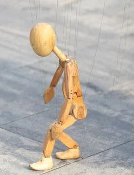 Wooden puppet is being pulled by a string Foto stock