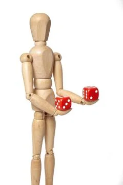 Wooden puppet with dice Stock Photos
