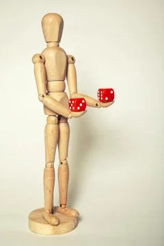 Wooden puppet with dice Stock Photos