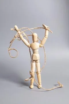 Wooden puppet with strings on gray background. Concept of emotional manipulat Stock Photos