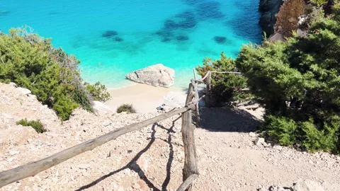 Wooden railing path leading down to the secluded turquoise Cala Goloritz be.. Stock Footage 347825646