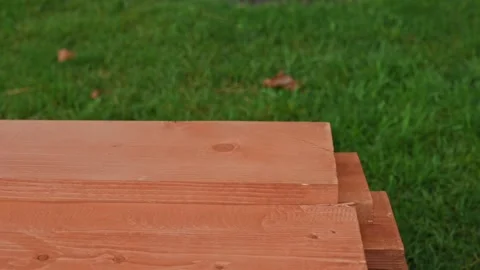 Wooden rectangular bars for construction against the background of green lawn Видео 220721840