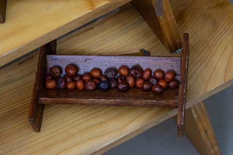 Wooden, rectangular container is filled with brown seeds or small fruits, Foto stock