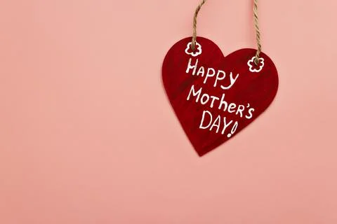 Wooden red heart with white inscription happy mother's day on twine and pink Stock Photos