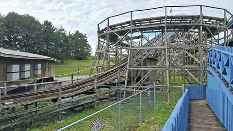 Wooden roller coaster structure standing in an amusement park. Stock Photos