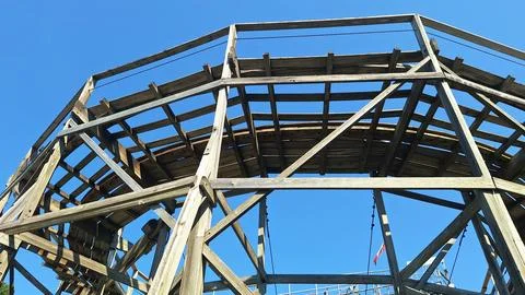 Wooden roller coaster track structure against blue sky. Stock Photos