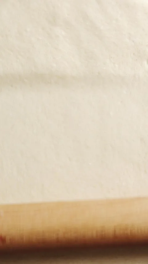 Wooden rolling pin rolls flatbread dough into thin layer. Stock Footage 341951445