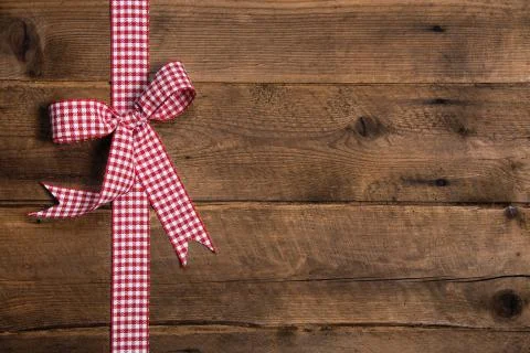 Wooden rustic background with a red white checkered ribbon. Stock Photos