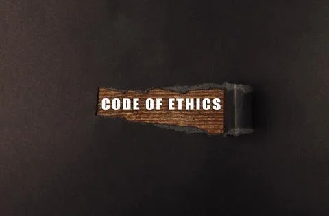 Wooden sign displaying the phrase "Code of Ethics" on a dark textured background Stock Photos