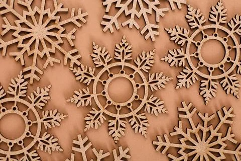 Wooden snowflake patterns on a brown background Stock Photos