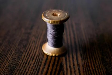 Wooden spool of thread. Purple thin thread. Dark background Stock Photos