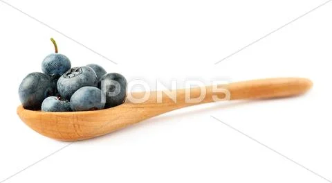 Wooden spoon filled of Bilberry or blueberry over isolated white background Stock Photos