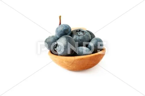 Wooden spoon filled of Bilberry or blueberry over isolated white background Stock Photos