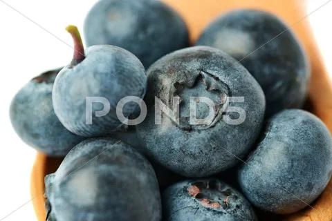 Wooden spoon filled of Bilberry or blueberry over isolated white background Stock Photos