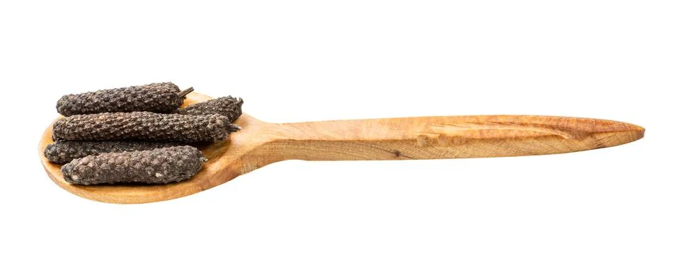Wooden spoon with java long peppers isolated Photos
