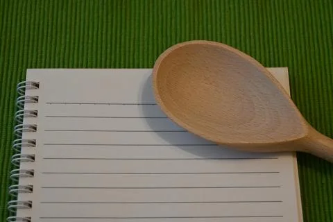 Wooden spoon on lined notebook Fotos Stock