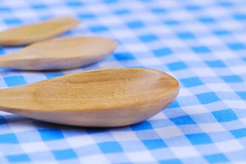 Wooden spoon,  tablecloth, fork on table background Stock Photos