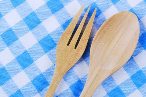 Wooden spoon,  tablecloth, fork on table background Stock Photos