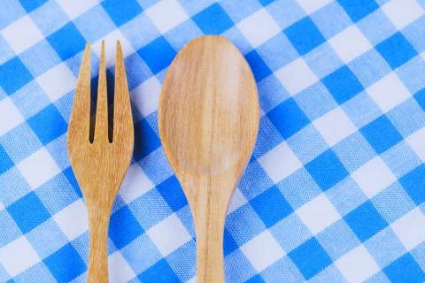 Wooden spoon,  tablecloth, fork on table background Stock Photos