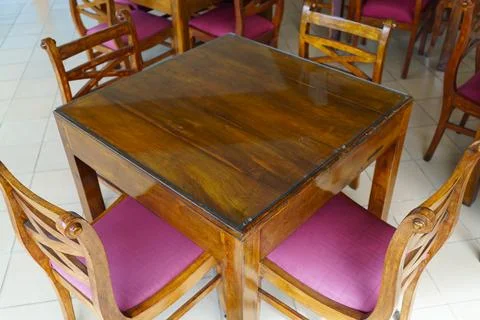 Wooden square dining table and four chairs Stock Photos