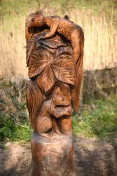 Wooden squirrel carved in woodland post Stock Photos