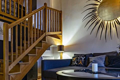 Wooden staircase to second floor in tiny living room, wall decor in the form  写真素材