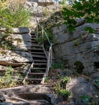 Wooden stairs up to hill between rock walls in forest Stock Photos