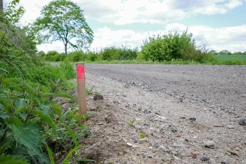 A wooden stake marks the width of a path for the road builders Stock Photos