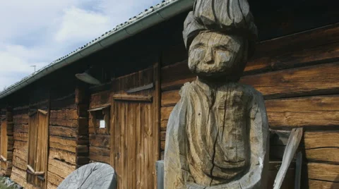 Wooden statue against log cabin. Hand held Stock Footage